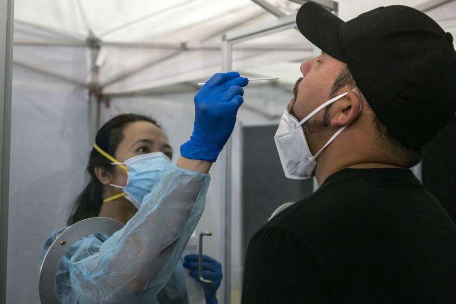 Trabajadora médica administra una prueba rápida de COVID-19 a un viajero en el Aeropuerto Internacional de San Francisco (SFO), en EE.UU.
