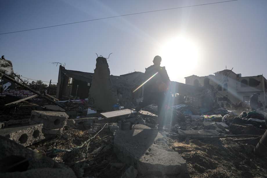 Palestinos buscan cadáveres y sobrevivientes entre los escombros, tras un ataque aéreo israelí en Deir Al Balah, al sur de la Franja de Gaza. 