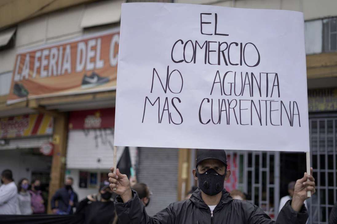 un hombre sostiene un cartel que dice: el comercio no aguanta más cuarentena.