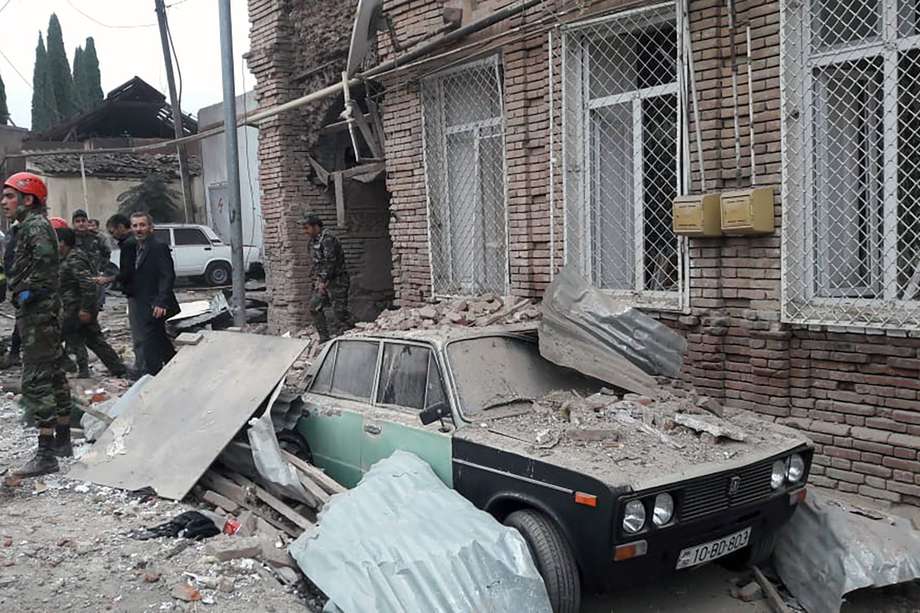 El personal de emergencias trabaja en un área dañada de la ciudad de Ganja (Azerbaiyán) luego de un ataque con cohetes armenios el 4 de octubre de 2020, durante los combates en curso entre Armenia y Azerbaiyán por la región separatista de Nagorno-Karabaj.