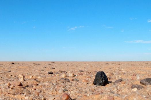 Fragmento negro del meteorito Almahata Sitta encontrado en el desierto de Nubia al norte de Sudán.  / SETI Institute/NASA Ames