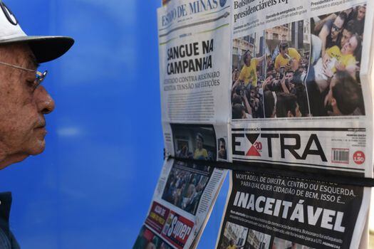 Un hombre observa los titulares de la prensa sobre el desarrollo de la campaña electoral en Brasil. / AFP