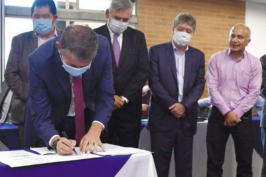 El ministro de Trabajo, Ángel Custodio Cabrera, firma el acta del acuerdo sobre el mínimo, rodeado de representantes gremiales y sindicales.  / Óscar Pérez