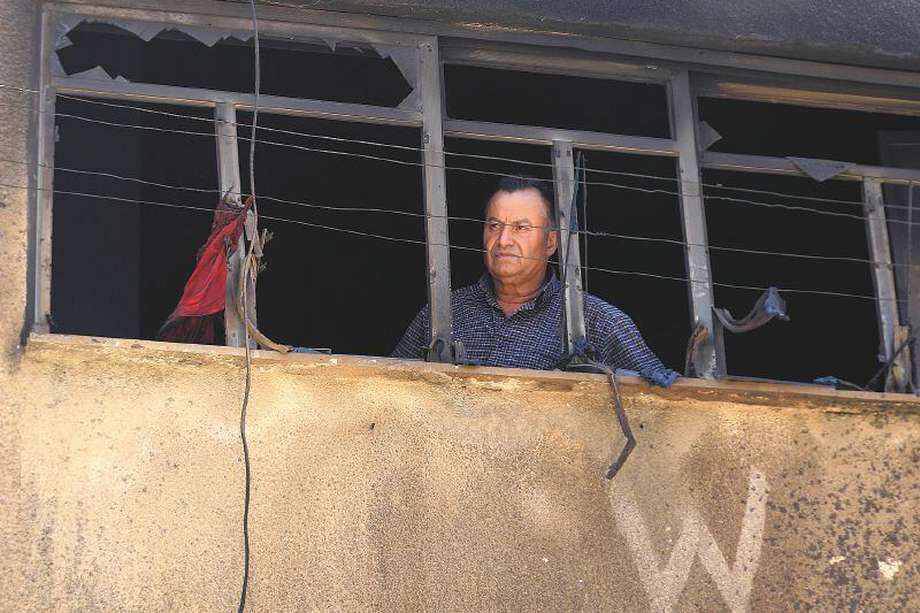 Un hombre mira desde la ventana rota de un edificio en el campo de refugiados de Yenín, en Cisjordania, tras una operación militar israelí a gran escala en julio pasado.  