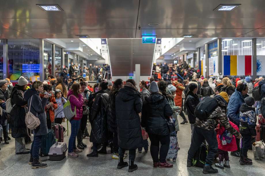 Decenas de refugiados procedentes de Ucrania esperan en la estación de tren de Cracovia, Polonia, mientras que los grupos de voluntarios reparten comida y bebidas. 
