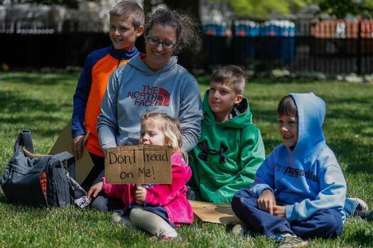 Protestas en Virginia en contra de las medidas de confinamiento: "No me pisotees", dice el letrero de la niña.  / EFE