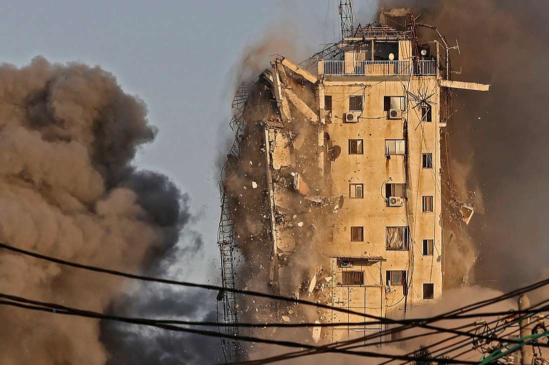 El humo se eleva desde la torre Al-Sharouk mientras se derrumba después de ser golpeada por un ataque aéreo israelí, en la ciudad de Gaza el 12 de mayo de 2021