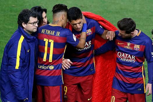 Neymar y Messi consuelan a Suárez tras la lesión.  / EFE