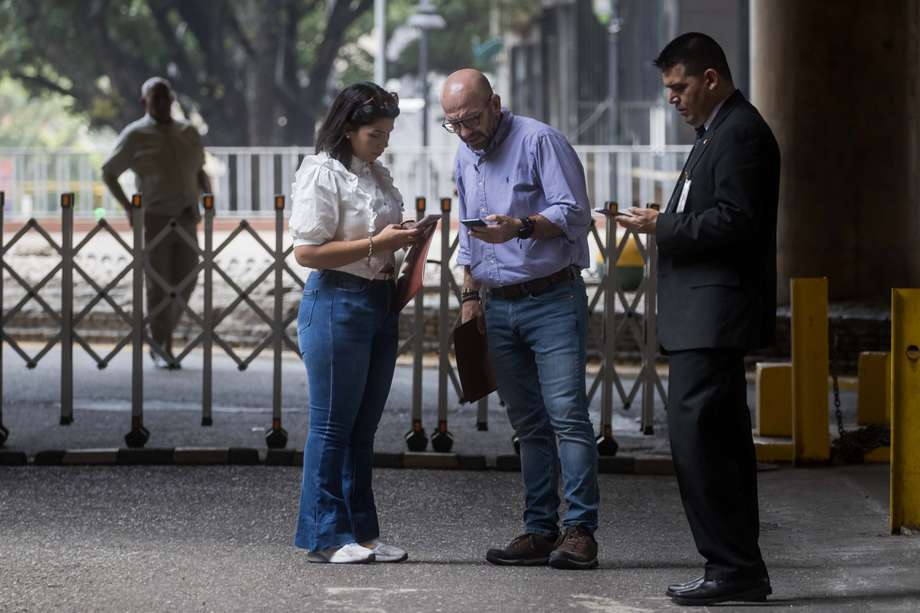 Angel Christian Palmeri Bacchi y Diana Carolina Rodríguez, representantes del partido político "Un Nuevo Tiempo", aguardan para ser atendidos en la sede principal del Consejo Nacional Electoral este martes, en Caracas (Venezuela). 

