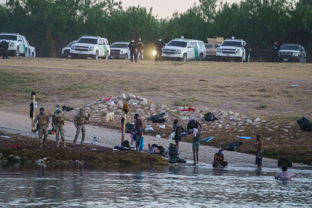 Haitians cross the Rio Grande towards the US under the watch of US Border Patrol, after Mexican police and National Institute of Migration officials blocked the Mexican side of the border at Parque Ecologico Braulio Fernandez in Ciudad Acuna, Coahuila state, Mexico on September 23, 2021. (Photo by PAUL RATJE / AFP)