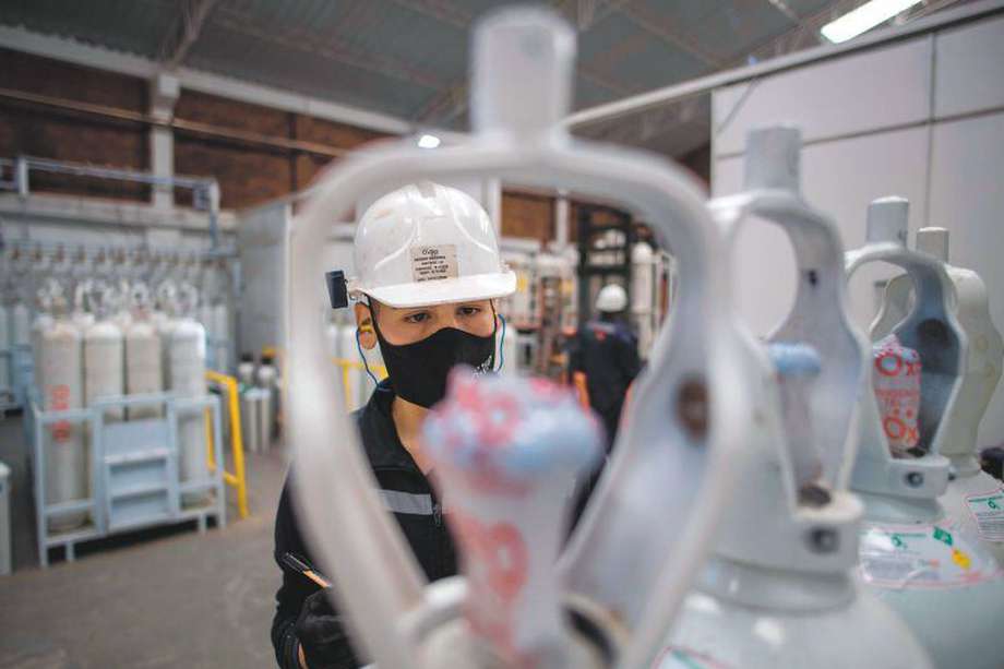 A worker checks oxygen cylinder to be used in intensive care units for COVID-19 patients in Bogota on January 29, 2021. / AFP / Juan BARRETO

