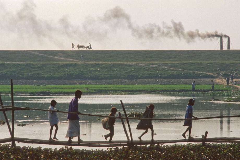 La agricultura está asociada a más del 50 % de las enfermedades infecciosas zoonóticas que han afectado a los seres humanos desde 1940.  En la foto, una familia camina por canales inundados en Bangladesh.