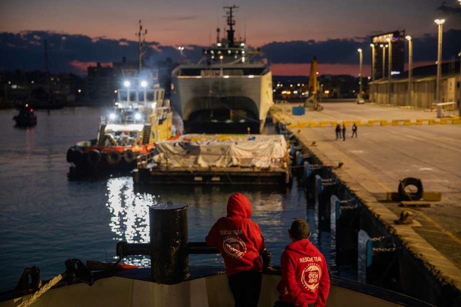 Una fotografía proporcionada por las organizaciones no gubernamentales Open Arms y World Central Kitchen muestra a miembros del personal cerca de una barcaza con la ayuda alimentaria para Gaza que será llevada por un barco coordinado por dos ONG.