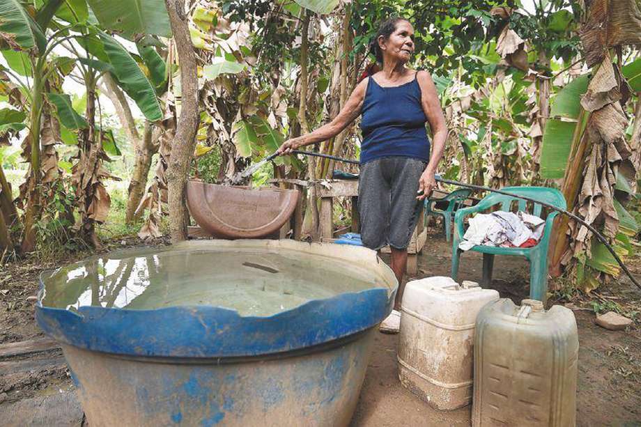 Alicia Arroyo llena un tanque con el agua que le llega del pozo. / Mauricio Alvarado
