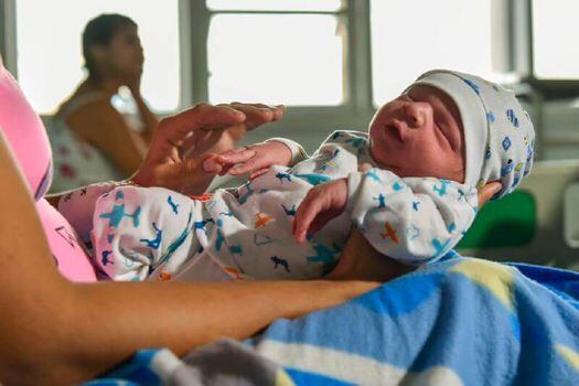 Una mujer venezolana carga a su bebé recién nacido en el hospital Erasmo Meoz, de Cúcuta. / AFP