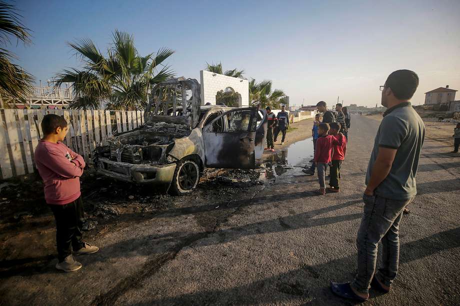 Un grupo de personas observa el carro de la organización World Central Kitchen (WCK) que quedó destruido tras un bombardeo israelí en Gaza.