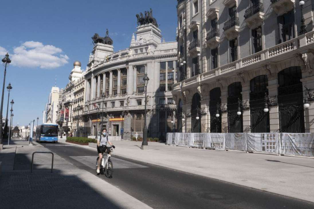 Un hombre pasea en bicicleta con mascarilla por Madrid.
