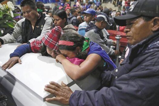 Familiares y amigos de uno de los líderes indígenas asesinados lloran sobre su féretro en el sepelio, en Corinto (Cauca).  / AFP