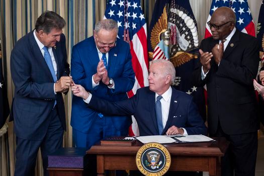 El presidente Joe Biden entrega el bolígrafo con el que firmó la Ley de Reducción de la Inflación al Senador demócrata Joe Manchin. 
