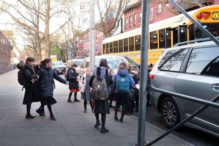 Un grupo de niños se reúnen para subir a un autobús escolar en Brooklyn, Nueva York.