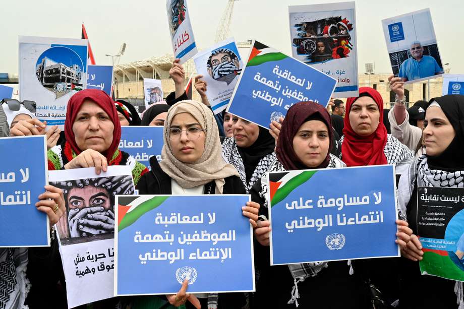 Los residentes palestinos en el Líbano llevan carteles que dicen en árabe "No a castigar a los empleados por cargos de afiliación nacional" durante una protesta contra la directora de Asuntos de la UNRWA en el Líbano, Dorothee Klaus, frente a las oficinas de la UNRWA en Beirut, Líbano, el 27 de marzo de 2024.

