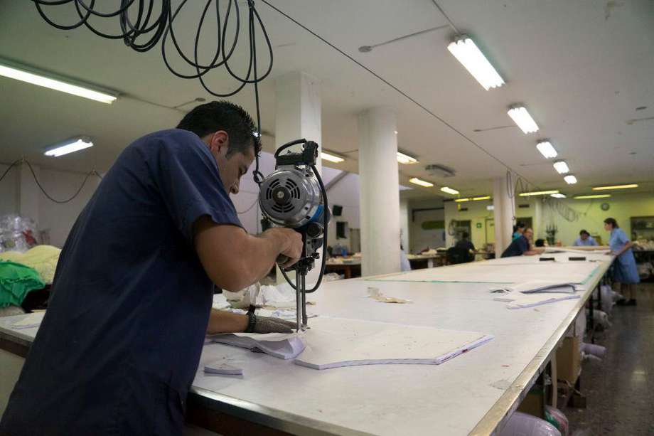 A worker cuts a piece of fabric at the Touche factory in Medellin, Colombia, on Monday, Aug. 25, 2014. Touche designs and manufactures swimwear and lingerie for sale domestically and for export. Colombia's economy will grow by about 5 percent this year, with industry continuing a "process of slow recovery," central bank co-director Adolfo Meisel said earlier this month. Photographer: Mariana Greif Etchebehere/Bloomberg