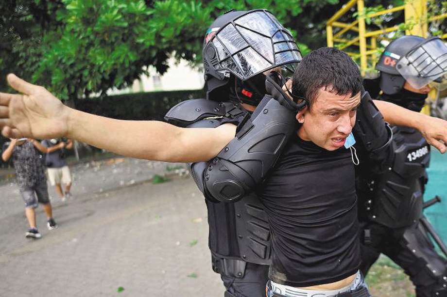 Colombian police officers arrest a demonstrator during a protest against the government in Cali, Colombia, on June 4, 2021.  / AFP / Luis ROBAYO
