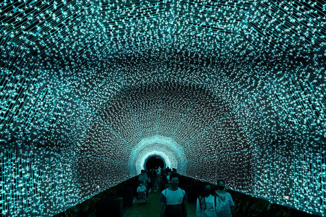 Los visitantes caminan a través de un túnel de luces durante Christmas Wonderland en Gardens by the Bay en Singapur.