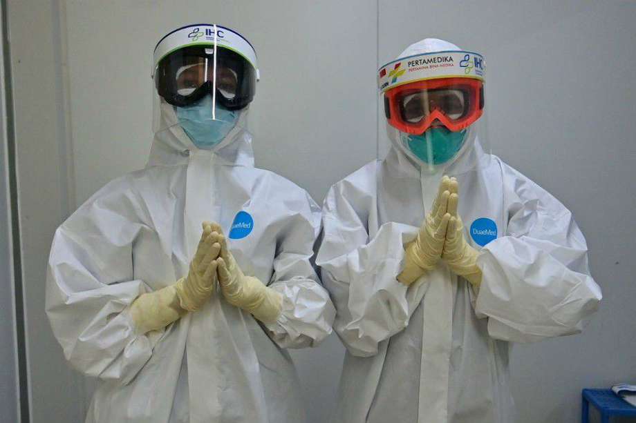 Dos enfermeras en Yakarta, Indonesia, hacen un gesto antes de entrar a una sala para pacientes con Covid-19.