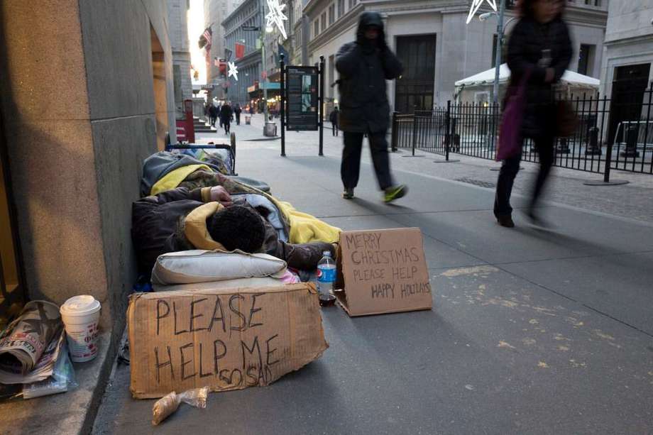 Un indigente duerme en Wall Street, cerca de la Bolsa de Valores de Nueva York.