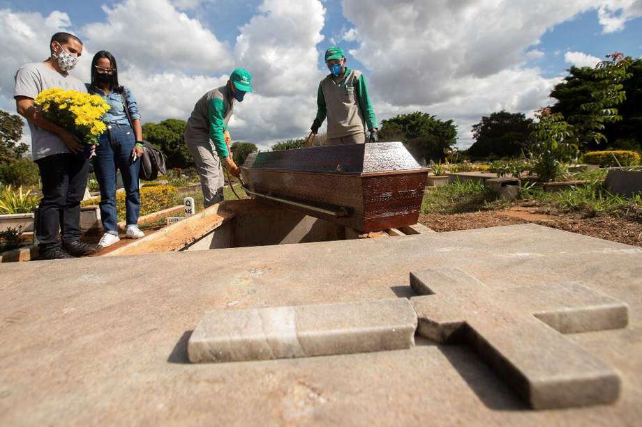 Empleados de un cementerio preparan a los muertos por coronavirus para ser enterrados.