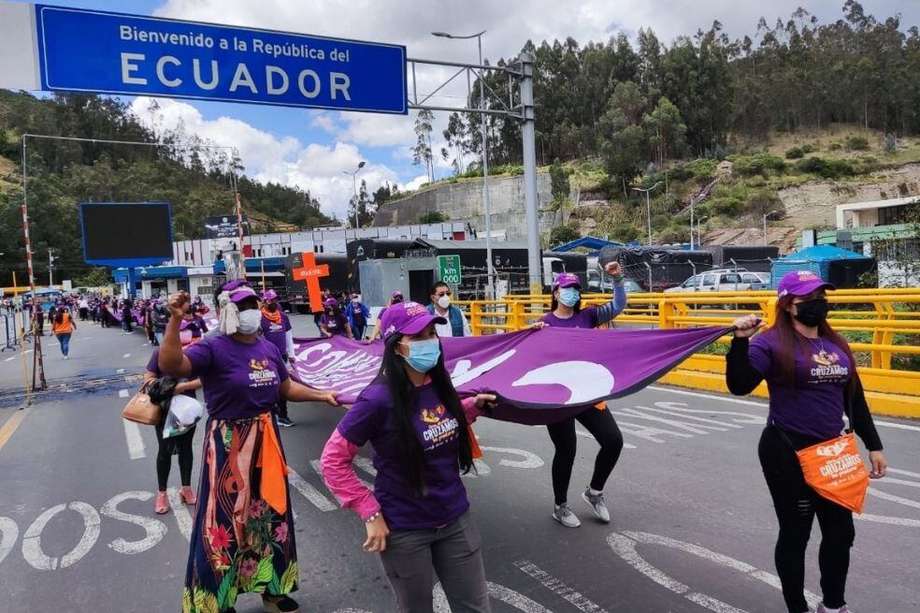 Un grupo de mujeres migrantes marcha en el Puente Internacional de Rumichacha, frontera de Ecuador con Colombia, para exigir su reapertura.
