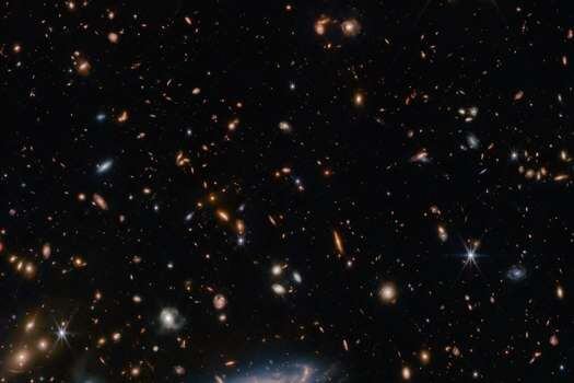 Imagen captada por el telescopio espacial James Webb que muestra estrellas y galaxias que rodean la galaxia espiral LEDA 2046648