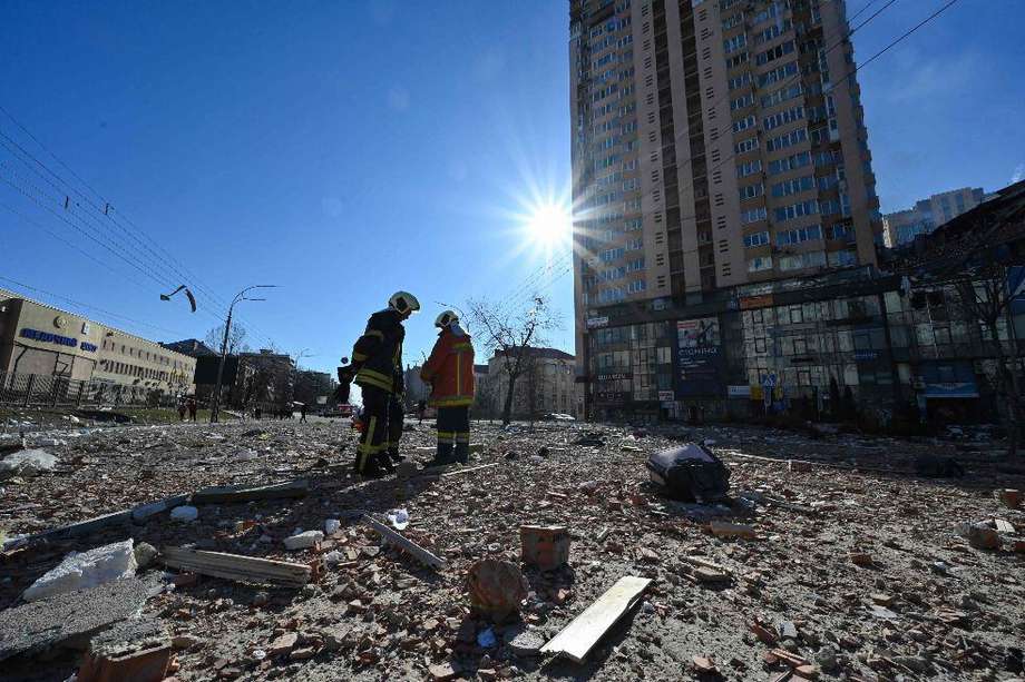 Bomberos revisan un edificio de apartamentos en Kiev que fue alcanzado por artillería rusa.