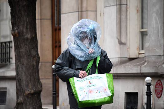 Un hombre en Francia, en donde se decretó una cuarentena casi total, se protege con una bolsa plástica. / AFP