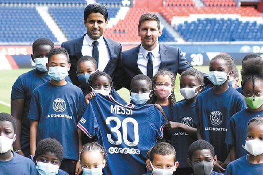 Messi posa con niños de la fundación PSG y con Nasser Al-Khelaïfi, presidente del club.  / AFP
