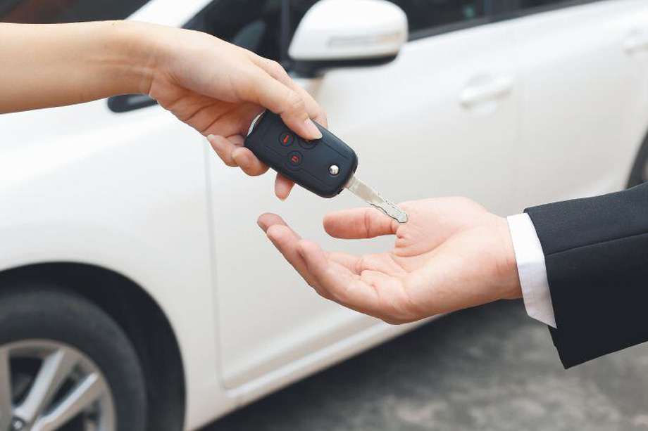 Female hand giving a key for buyer or rental car.