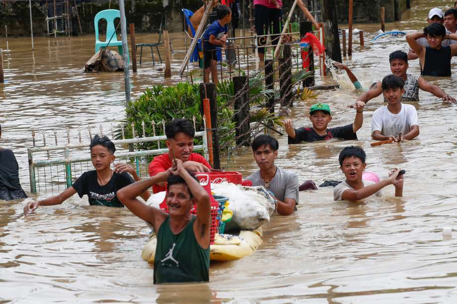 Residentes cruzan las aguas de la inundación provocada a finales de septiembre por el tifón Noru en la localidad de San Miguel de la provincia de Bulacan, al norte de Manila, Filipinas. 