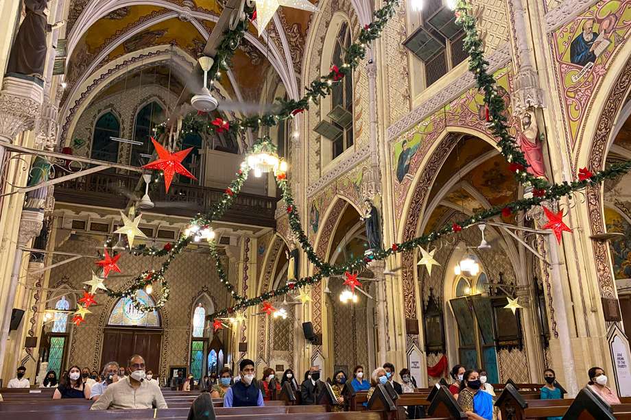 Con uso de tapabocas y distanciamiento social, los devotos cristianos participan en una misa en la víspera de Navidad, en Mumbai (India)