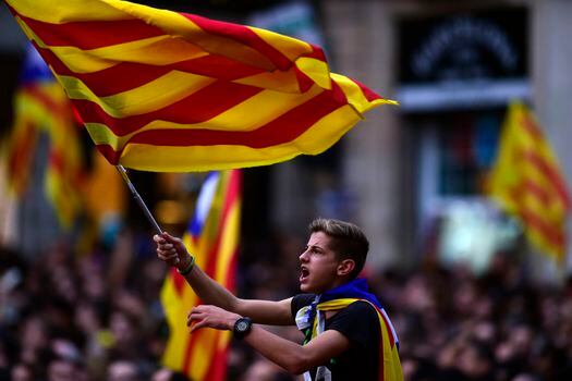 Un niño agita la bandera de Cataluña en la celebración del viernes en la plaza Sant Jaume en Barcelona.  / AFP