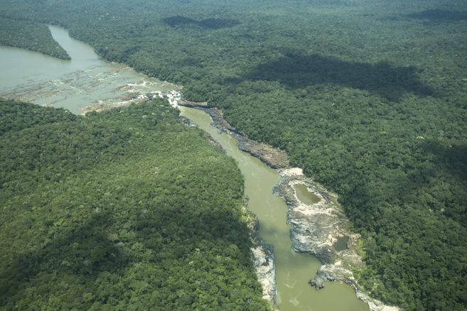 Aerial shot of the Jirijirimo waterfall and surrounding forest and river.