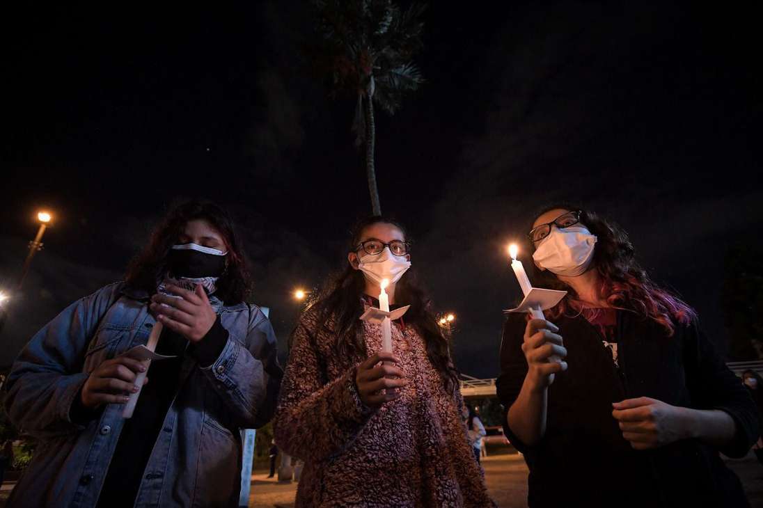Tres mujeres sosteniendo velas