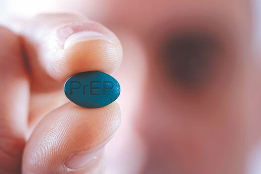 closeup of a young caucasian man with a simulated PrEP pill in his hand