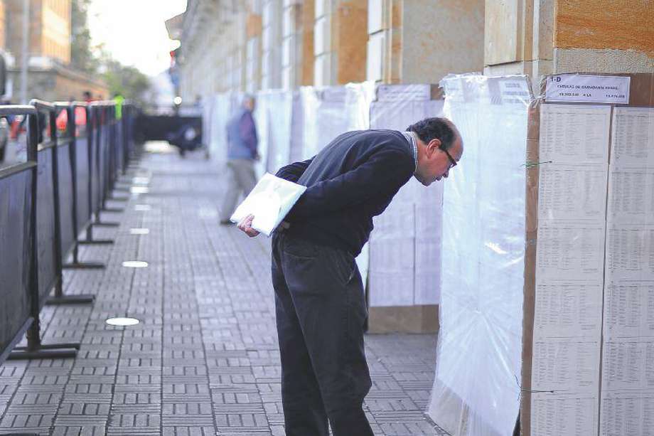 Un hombre observa las listas de cédulas en la plaza de Bolivar