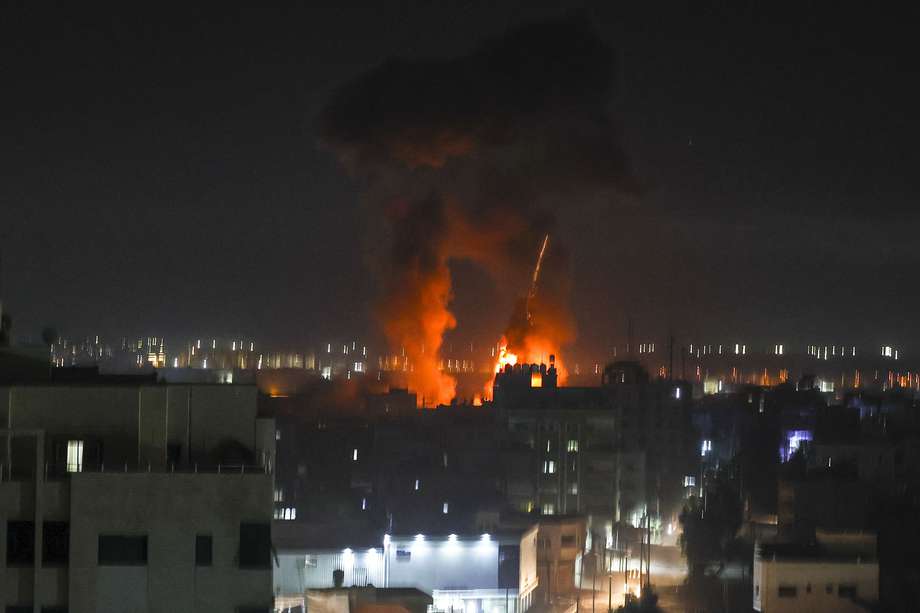 Las explosiones iluminan el cielo nocturno sobre los edificios en la ciudad de Gaza mientras las fuerzas israelíes bombardean el enclave palestino