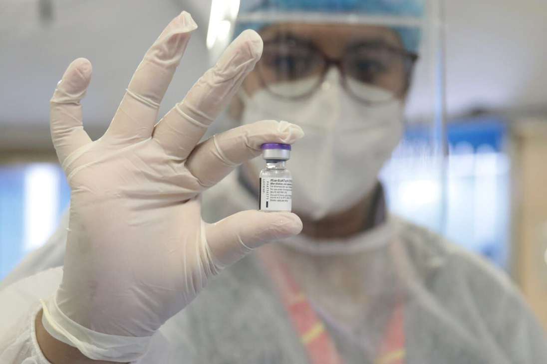 Una mujer sosteniendo uno de los frascos de la vacuna