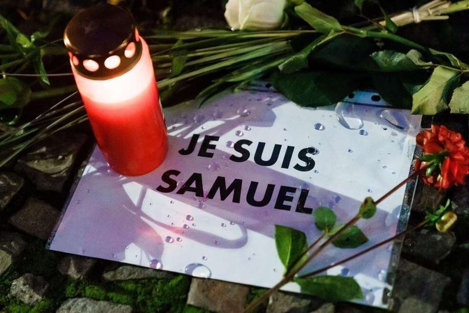 Una vela y un mensaje en el que se lee en francés 'Soy Samuel' son vistos durante una vigilia para rendir homenaje a Samuel Paty, profesor de francés decapitado en París, Francia.