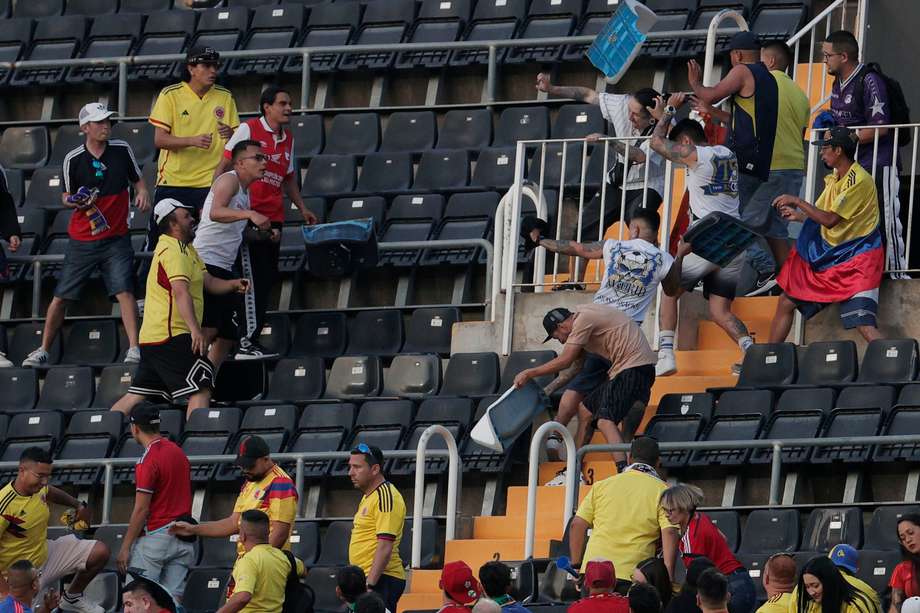 Los aficionados colombianos enfrentados en Valencia en pleno partido de la selección. 