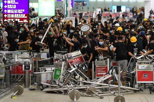 Los manifestantes bloquearon la entrada a las terminales del aeropuerto de Hong Kong y generaron la cancelación de los vuelos por segundo día consecutivo el martes. / AFP