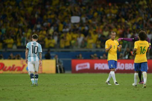 Los jugadores de Brasil celebran, mientras Lionel Messi, capitán de Argentina, se lamenta. / AFP